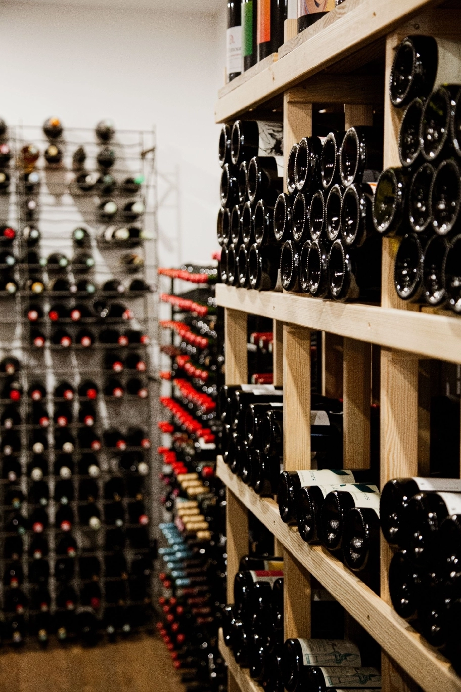 vigneron se tenant devant des bouteilles dans une cave à vins