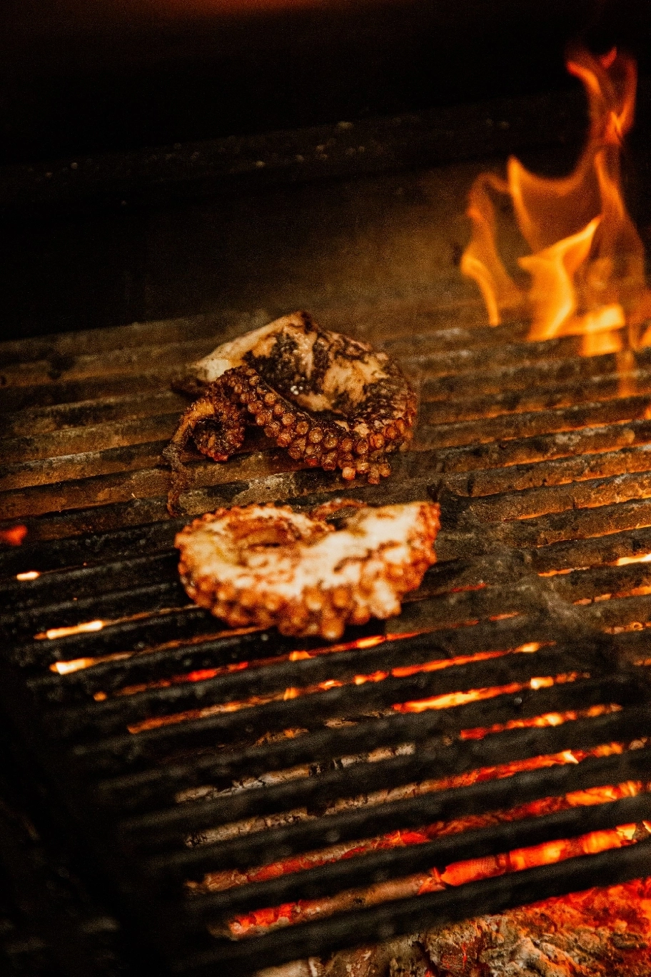 viande de boeuf cuisiné au feu de bois avec une personne rajoutant du sel dessus